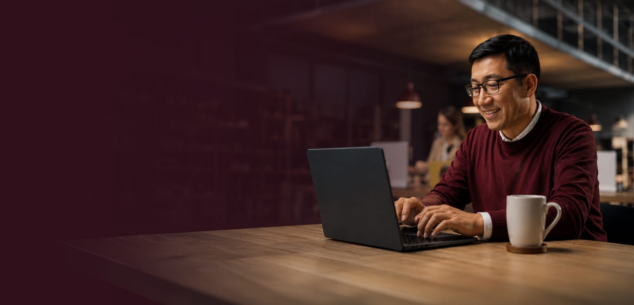 A man working on a laptop at a shared table in a co-working space